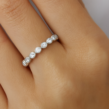 Load image into Gallery viewer, Silver ring with small diamonds on a finger against a neutral background
