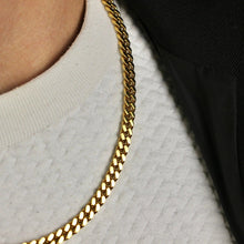 Load image into Gallery viewer, Gold chain necklace worn by a person on a light gray background
